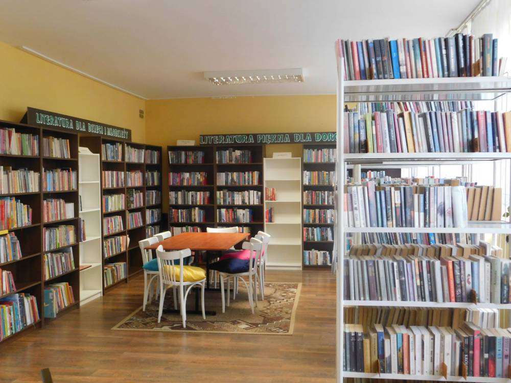 zdjęcie przedstawia pomieszczenie biblioteki widać na nim regały z książkami 